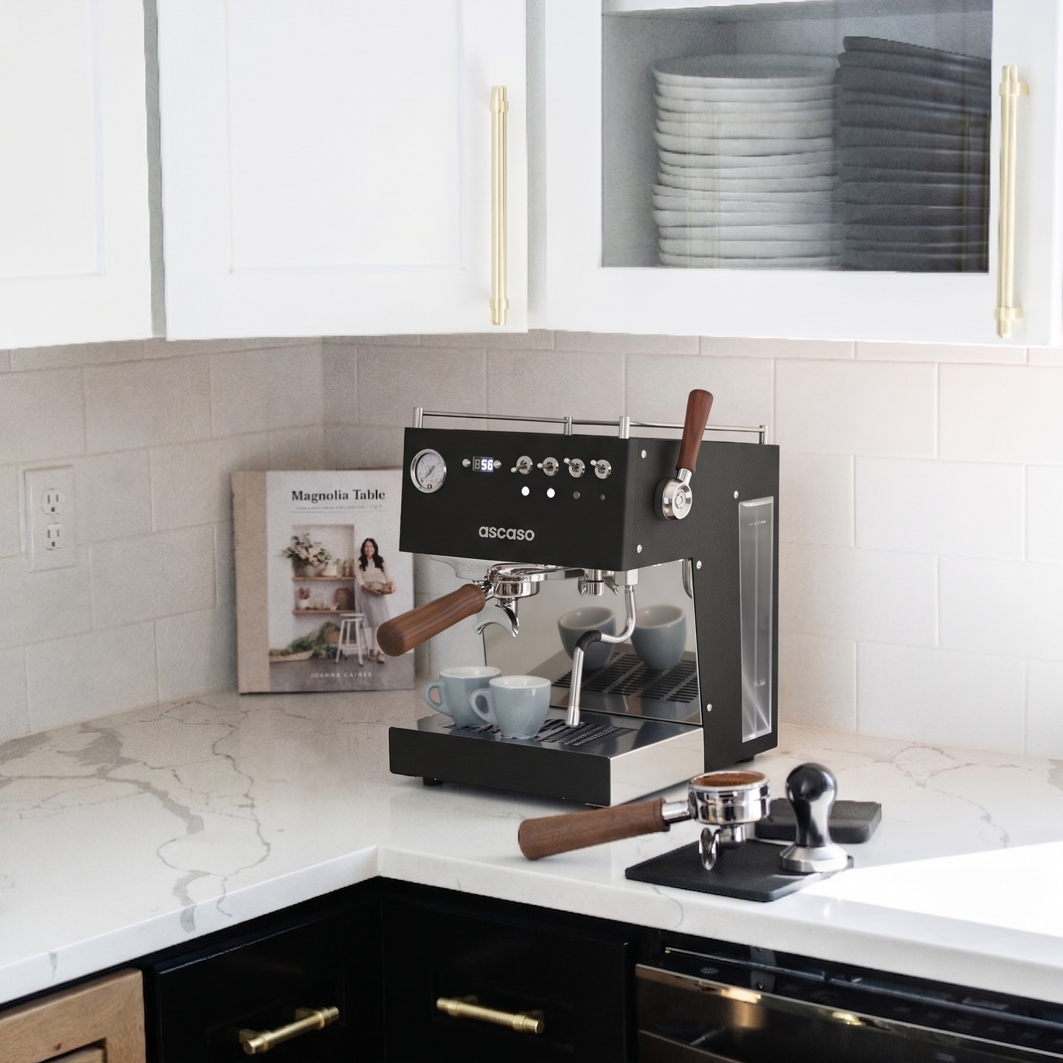 Espresso machine on a kitchen counter with white cabinets and marble countertop.